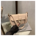 Detail shot of beige patent leather bag featuring a glossy finish and gold horseshoe buckle - Khaki