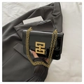 Detalle del bolso bandolera de charol negro con cadena dorada y hebilla cuadrada metal - Negro