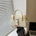 Elegante borsa a tracolla in pelle crema con fibbia sul davanzale al sole - Bianco