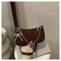 Dettaglio della borsa baguette in pelle scamosciata marrone con catena e ciondolo a fiocco - caffè