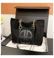 Dettaglio borsa tote in pelle scamosciata nera con catena dorata e logo goffrato - Nero