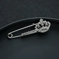 Detailed macro shot of a silver crown brooch with sparkling crystal rhinestones inlay - Silver