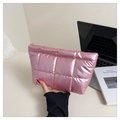 Pink metallic quilted cosmetic bag with gold zipper shown in a lifestyle office setting - Pink