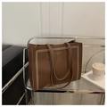 Détail du sac cabas marron en cuir grainé avec l'inscription dorée FASHION & BAGS - café