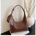 Detail of brown litchi pattern leather baguette bag with decorative silk scarf - Coffee