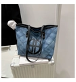 Detailopname van geruite denim tote bag met rond logo op een witte reiskoffer - Donkerblauw
