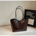 Detailed macro of dark brown oily wax leather tote with sleek gold hardware - Coffee