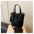 Detalle del bolso tipo cubo en cuero negro con costuras y hebilla de correa metálica - Negro