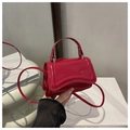 Glossy red patent leather mini handbag with curved base and silver hardware accents - Red