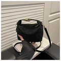 Close-up of black leopard print suede handbag with elegant gold twist lock detail - Black