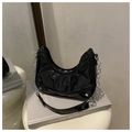 Detail der glänzenden schwarzen Hobo-Tasche mit Silberkette und Lackleder-Faltenstruktur - Schwarz