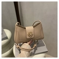 Dettaglio della borsa a tracolla in pelle beige con fibbia floreale dorata e nodo - Cachi