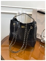 Detail van zwarte gewatteerde leren tas met gouden ketting en metalen draaisluiting - Zwart