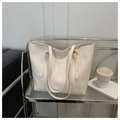 Detalle de un bolso tote de cuero blanco crema en un estante con decoración minimalista - Blanco