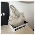 Detailed view of beige corduroy tote bag featuring side pocket and textured fabric finish - Off White
