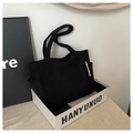 Detail shot of black corduroy tote bag showing vertical ribbed texture and stitching - Black