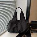 Minimalist black tote bag with natural pleats and zipper closure in office setting - Black