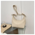 Close-up of beige lychee grain leather underarm bag with gold metal buckle detail - White