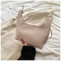Détail du sac bandoulière en cuir texturé premium dans un décor de style de vie - Blanc Cassé