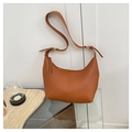 Close-up of caramel leather hobo bag with litchi texture and adjustable strap - Brown