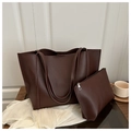 Dettaglio del set borsa tote marrone scuro con pochette coordinata su tavolo - caffè