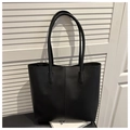 Detalle de bolso tote negro minimalista con costura central decorativa y asas largas delgadas - Conjunto De Dos Piezas De Bolso Tote Y Bolso De Mano / Negro