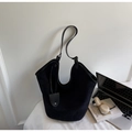 Detalle de bolso tote negro minimalista con asa de piel fina y colgante de gota elegante - Negro