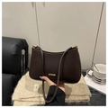 Dettaglio di borsa a mezzaluna marrone scuro con placca dorata su tessuto a maglia - caffè