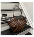 Detailed close-up of checkered tote bag with V-shaped edge and round mini pouch charm - Coffee