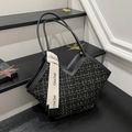 Tweed tote bag in black with gold stitching and leather trim displayed on stairs - Black