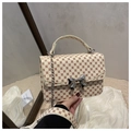 Detail of cream crossbody bag with vintage monogram patterns and metal bow clasp - Monogram Khaki