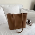 Bolso tote marrón minimalista en sofá blanco con auriculares y libros de tendencia - Marrón Oscuro