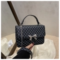 Detailed shot of a navy polka dot mini bag featuring a silver bow-knot metal clasp - Black Monogram