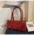 Détail du sac bandoulière en cuir verni rouge foncé brillant avec boucles argentées - Bordeaux