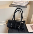 Détail du sac d'épaule noir brillant avec boucle en métal et texture de couture chic - Noir