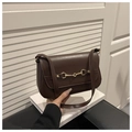 Detalle del bolso marrón oscuro con hebilla de bocado dorada y correa de hombro larga - café