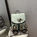 Vintage preppy backpack with lace bow and mint green stars print on a white stool - Green