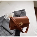 Brown crossbody bag with gold buckle detail on a white surface with blazer - Brown