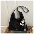 Detail of black leopard print suede hobo bag with schnauzer charm on glass coffee table - Black With Pendant