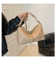 Detail der beigen Handtasche mit Lychee-Ledertextur, dekorativem Knotengurt und Goldbeschlägen - Khaki