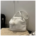 Detalle de bolso tipo almohada de piel sintética blanca con pompón sobre alfombra suave - Blanco Con Colgante