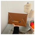 Detail der braunen Webstruktur an einer Umschlagtasche mit goldener Schließe - Braun