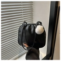 Detalle de bolso de hombro en charol negro con un colgante de pompón blanco suave - Negro Con Colgante