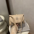 Borsa a tracolla beige in ecopelle con fibbia argentata e cerniere decorative in mano - Cachi
