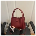Detalle de bolso tipo cubo granate en cuero con asas largas y correa fina de hombro - Rojo