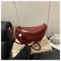 Detalle del bolso de media luna burdeos con correa anudada y accesorio de mármol - Rojo