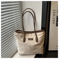Detail van de duurzame nylon stof en leren afwerking op de crèmekleurige tote tas - Wit & Koffie