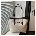 Detail van minimalistische oxford tote bag in crème met zwarte randen en merklogo-label - Wit en Zwart