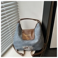 Detail einer blauen Segeltuchtasche mit braunem Lederbesatz und Retro-Stickerei-Akzenten - Blau