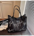 Bolso tote negro vintage con bordado de ondas y textura en un entorno urbano chic - Negro